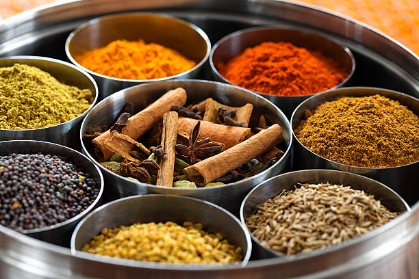 whole and ground spices neatly organized in a metal tin.